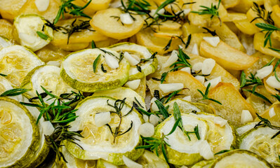 slices of freshly baked potatoes and zucchini with dill and garlic