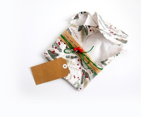 Torn and empty Christmas wrapping with wrapping paper, twine, ribbon, present topper and a blank gift tag. Copyspace, isolated on white background. Opening Christmas gift or present concept.