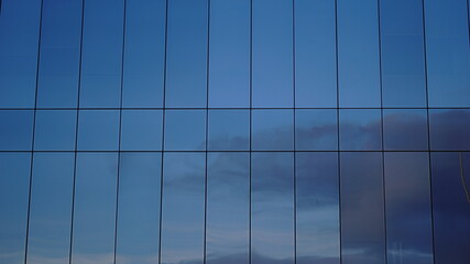 clouds reflected in building glass facade