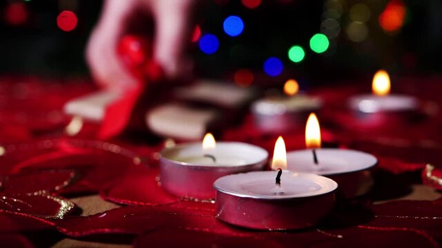 Tealight candles at Christmas with bokeh lights and gift
