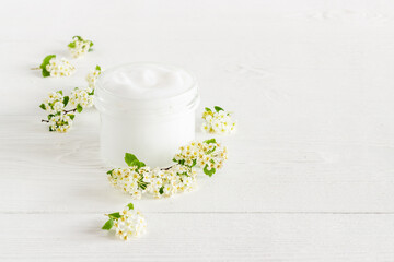 White moisturizing cream cosmetic for spa treatment with blossoms flowers