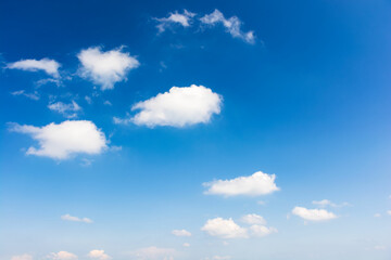 Naklejka na ściany i meble sky with fluffy clouds. white cumulus sparse cloudscape on a deep blue gradient of atmosphere. sunny summer weather. beautiful nature background. meteorology backdrop. fresh air. freedom concept