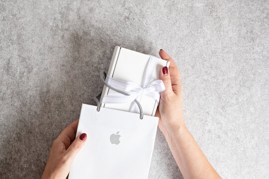 Lyon, France - December 15, 2021: Woman Unboxing Bag Of Apple Inc And White Box. Iphone, Ipad Or Accessories Gift For Holidays
