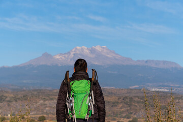 Anonymous man with only her back visible overlooking volcano iztaccihuatl. © Nailotl