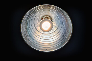 Incandescent work light on black background in HDR