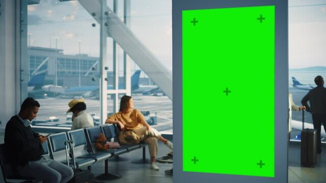 Airport Terminal: Green Screen Advertising Billboard. Arrival Departure Display With Chroma Key. Mock-up Space. Backgrond: Crowd Of People Wait For Their Flights In Boarding Lounge Of Airline Hub