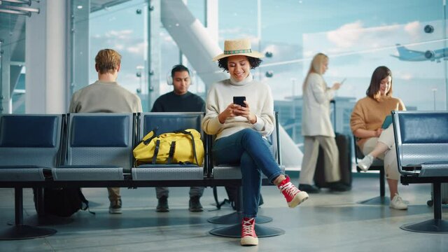 Airport Terminal: Diverse Multi-Ethnic Crowd of People Wait for their Flights, Usie Mobile Smartphones to Browse Interner, Post Vacations Photos on Social Media. Boarding Lounge of Big Airline Hub