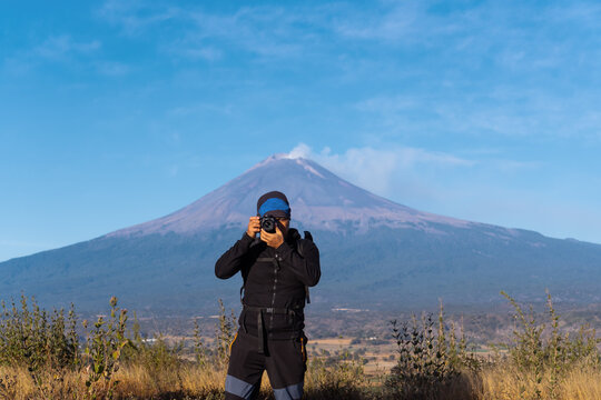a man taking picture of the volcano popocatepetl