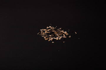 A mountain of husks from under the seeds lies on a black background