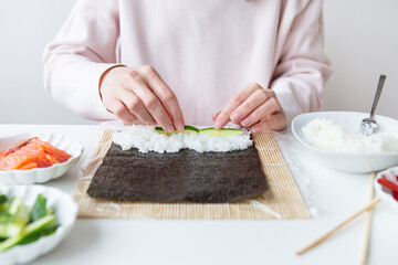 Sushi cooking process, girl makes sushi with different flavors.