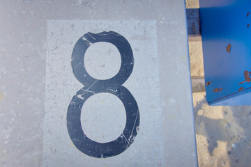 Scratched black numbers 8 on a metal surface