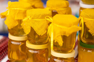 Composition with glass jar of honey on neutral pastel background. Alternative medicine, preventive medicine.