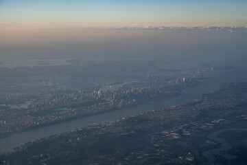 View from airplane above clouds and city