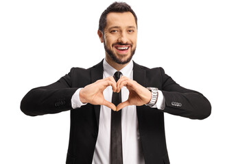 Young man in a suit and tie gesturing a heart symbol with hands