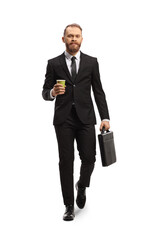 Full length portrait of a young businessman walking and holding a briefcase and a takeaway coffee cup