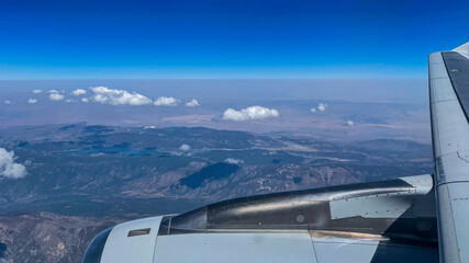 View from airplane above clouds and city