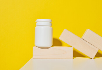 white plastic jar for pills, cream and medicines on a yellow background. Container for substances