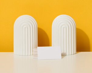 stack of white rectangular business cards on a yellow background, company branding, address.