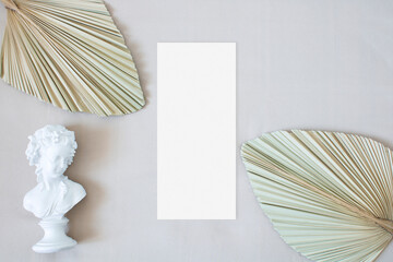 Mockup menu card with leaf palm and the statue on the nude fabric