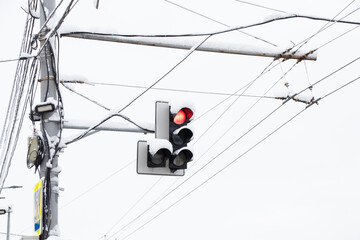 red traffic light on the background of the sky in winter in snow and ice in Ukraine