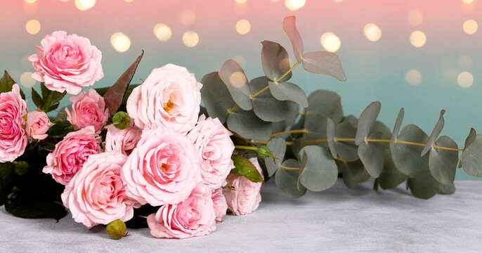 Beautiful summer banner for a website with a bouquet of pink roses and eucalyptus on the table
