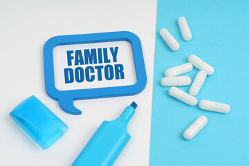 On the white and blue surface are a marker, tablets and a plate inside which the inscription - FAMILY DOCTOR