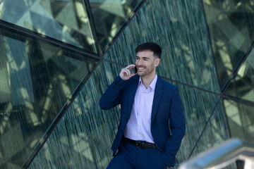 Fototapeta na wymiar Business man smiling on phone call. Modern area