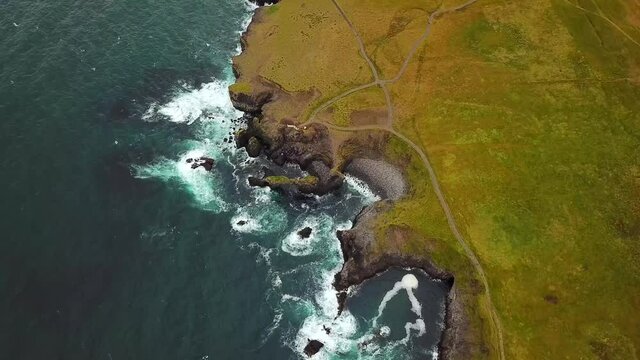 Amazing seascape, Gatklettur basalt rock arch at the volcanic cliff, Atlantic coast of Arnarstapi in the west of Iceland. Rocks and stones with abstract forms. Drone footage. Hollow in the ground. 