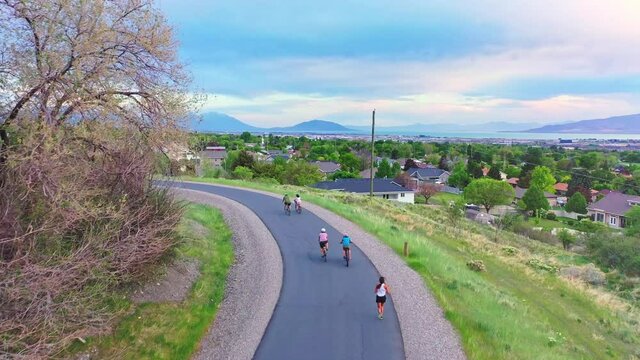 People run and ride bikes on Murdock Canal Trail in Utah Valley spring evening