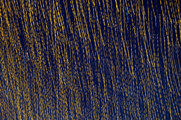 Abstraction blurred movement lights garlands. Golden lights of a blurred garland on the background of a purple blue sky. The concept of a night holiday night. Designer background of the New Year.