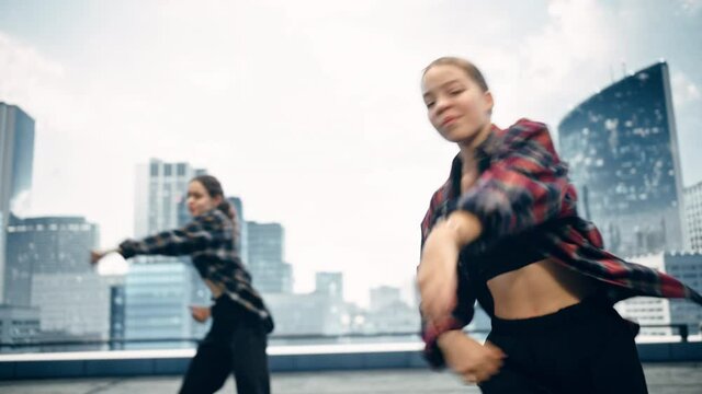 Diverse Group of Three Young Professional Dancers Performing a Hip Hop Dance Routine in Close Up in Front of a Big Led Screen with Modern Urban Skyline with Skyscrapers in Studio Environment.