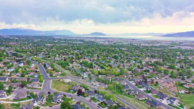 Aerial over Pleasant Grove Utah, late spring evening sunset with clouds and lake