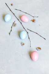 Happy Easter concept. Preparation for holiday. Colorful decorated easter eggs spring branches on concrete stone grey background. Simple minimalism flat lay top view copy space.