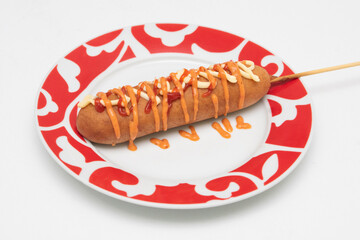 Banderillas o brochetas de salchicha empanizada con harina y servidas con aderezo picante.