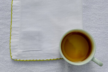 Cup of tea over a white handkerchief. Beautiful cup composition. Background.	