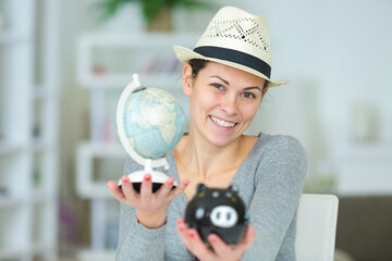 woman holding piggy bank with world globe