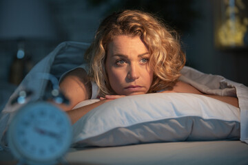 depressed woman laying awake at night