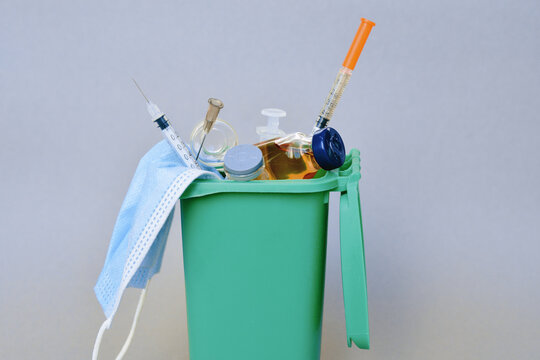 trash container with medical waste.  syringe, ampoule, vaccine,  face mask - medical pandemic items 