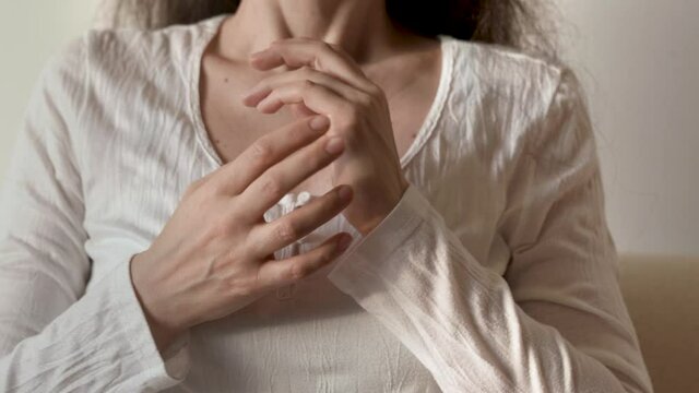 Woman in white shirt practicing EFT - tapping on the side of the hand or karate chop point