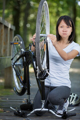 Obraz premium upset woman checking bicycle chain in the park