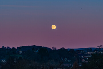 The Moon rising up over the belt of venus looking over the Cumbrian town of Penrith