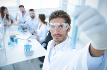 tube with reagents on blurred background laboratory.