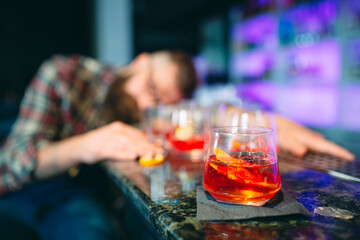 Drunk bearded man fell asleep at the bar.