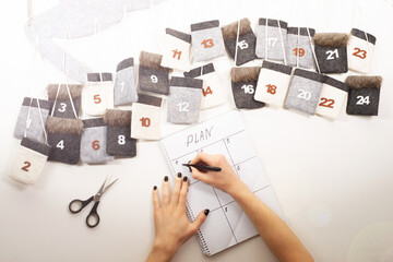 drawcalendar reminder with cells in the form of pockets.
drawing up a plan for the month, writes reminders on paper in columns for a homemade wall calendar