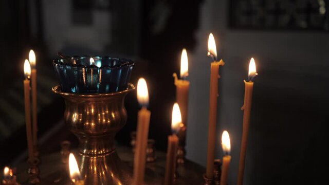 Burning candles in the church church. Close-up. High quality FullHD footage