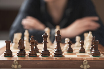 chess game the player is confidently waiting for the move of a chess piece from the opponent. Dark chess in the foreground, Chess pieces in a row chess game solid wood board square
