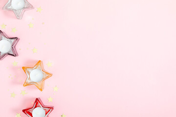 Pink festive background with stars. Candles on pink background, party. Flat lay, top view, copy space