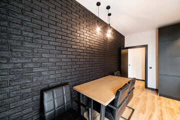 Kitchen in a house with black walls and a table made of wood