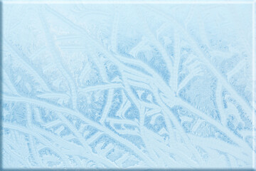 Cold frosty patterns on the window glass as a winter background. Winter texture. Frozen winter window, frost texture, snowflakes, New Year or Christmas decoration for banner, frame, greeting card