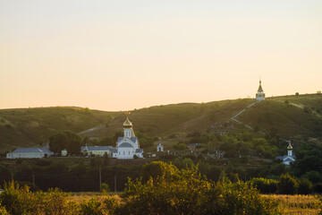 Evening view on architectural complex Holy Trinity Holkovsky Monastery and chalk hills. Holki village, Belgorod region, Russia.